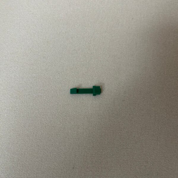 Small green plastic object on surface
