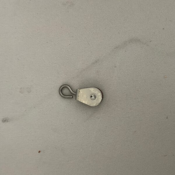 Small metal hook on gray surface.