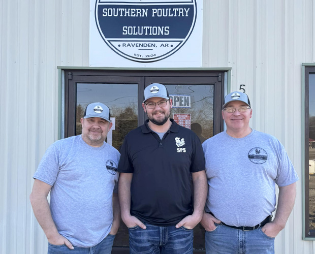 Three men in front of building.